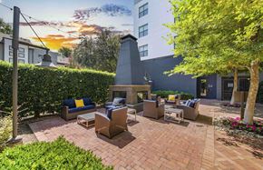 Dallas apartment for rent - a patio with chairs and a fireplace in front of a building
