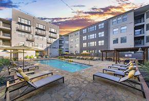 Dallas apartment for rent - a swimming pool in the middle of an apartment building at sunset