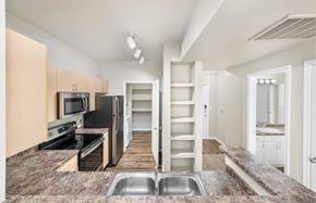 Grand Prairie apartment for rent - A kitchen with a refrigerator, microwave, oven, and sink.