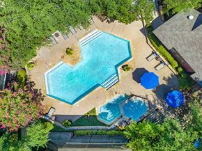 Plano apartment for rent - an overhead view of a swimming pool with trees and umbrellas