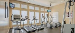Frisco apartment for rent - a gym with various cardio machines and televisions