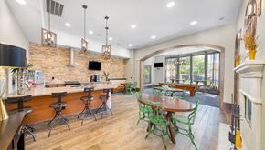 Cedar Park apartment for rent - a clubhouse with a bar and a dining area with tables and chairs