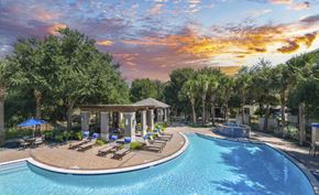 San Antonio apartment for rent - a swimming pool with lounge chairs and a fountain at sunset