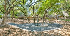 Austin apartment for rent - A tree-filled park with a circular playground in the middle.