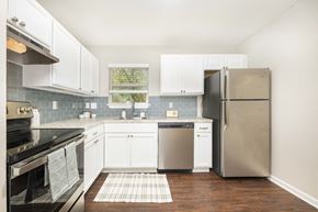 Austin apartment for rent - A kitchen with a black stove top oven and a black refrigerator.