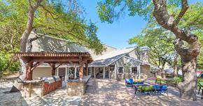 Austin apartment for rent - A building with a patio and trees in front.