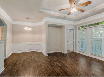 Modern living room with elegant crown moulding and wood plank vinyl flooring (in select units) 