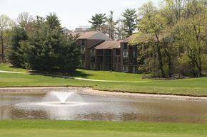 Reston apartment for rent - a pond with a fountain in front of an apartment building