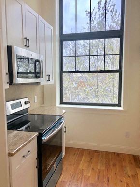 Newark apartment for rent - a kitchen with a stove microwave and a window