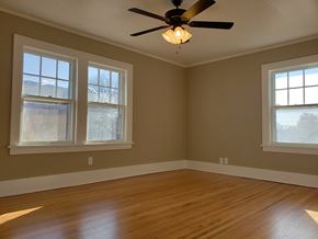 Omaha townhouse for rent - an empty room with a ceiling fan and three windows