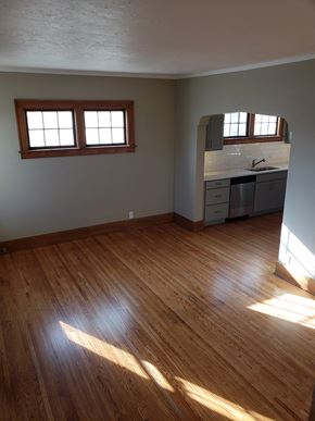 Omaha townhouse for rent - an empty living room with wooden floors and a kitchen