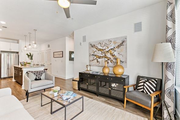 Jacksonville apartment for rent - A living room with a white couch, a coffee table, and a large painting on the wall.