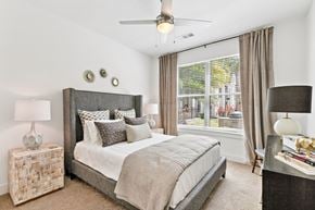Jacksonville apartment for rent - A bedroom with a large bed and a ceiling fan.