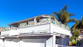 Laguna Beach triplex for rent - a white house with a palm tree next to it