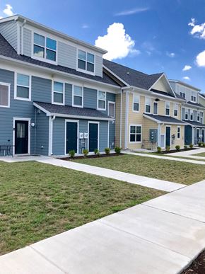 Cambridge apartment for rent - a row of blue houses with a sidewalk and grass