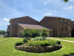Martinsburg apartment for rent - A large brick building with a landscaped front yard.