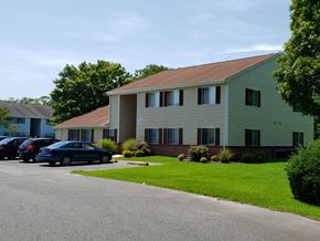 Pocomoke apartment for rent - A green house with a blue car parked in front.
