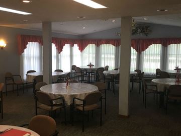 Tionesta apartment for rent - a dining room with tables and chairs and windows with curtains