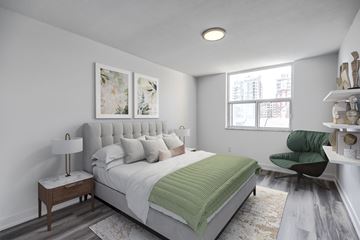 Burlington apartment for rent - A bedroom with a large bed and a green chair.