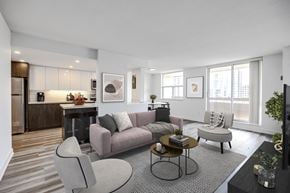 Burlington apartment for rent - A modern living room with a grey sofa, a coffee table, and a television.