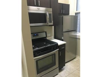 Chicago apartment for rent - a kitchen with a stove microwave and refrigerator