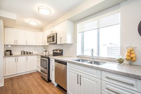 Kitchener apartment for rent - A kitchen with white cabinets and stainless steel appliances.