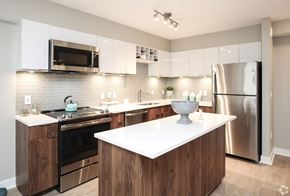 Washington apartment for rent - A modern kitchen with a white countertop and wooden cabinets.