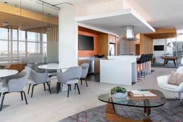 Washington apartment for rent - A modern living room with a glass table and grey chairs.