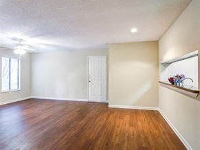 Sandy Springs apartment for rent - an empty living room with a wooden floor and a white door