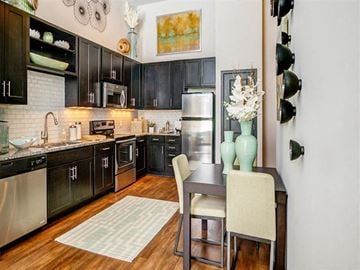 Nashville apartment for rent - a kitchen with black cabinets and a table and chairs