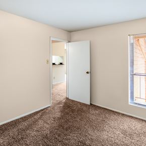 Spring apartment for rent - a bedroom with a carpeted floor and an open door to a bathroom