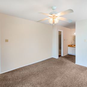Spring apartment for rent - a living room with white walls and a ceiling fan
