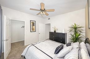 Houston apartment for rent - a bedroom with a large bed and a ceiling fan