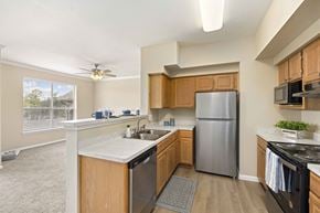 Houston apartment for rent - A kitchen with wooden cabinets and a stainless steel refrigerator.