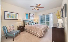 Houston apartment for rent - a bedroom with a large bed and a ceiling fan
