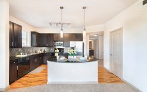 Houston apartment for rent - a large kitchen with black cabinets and a white counter top