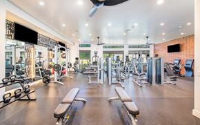 Houston apartment for rent - a gym with weights and cardio machines and a ceiling fan
