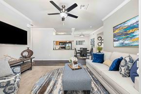Phoenix apartment for rent - A living room with a grey sofa, a coffee table, and a ceiling fan.
