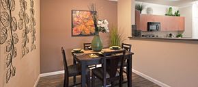 Gilbert apartment for rent - a dining room with a table and chairs and a vase with flowers