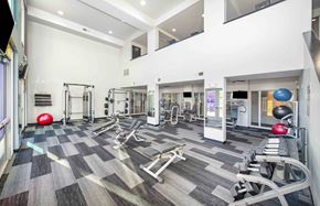 Scottsdale apartment for rent - a gym with cardio equipment and weights on a checkered floor