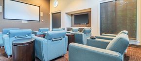 Coral Springs apartment for rent - a conference room with blue chairs and a projector screen