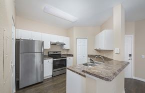 Palm Harbor apartment for rent - a kitchen with white cabinets and stainless steel appliances and a granite counter top