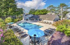Tampa apartment for rent - a backyard with a pool and chairs and a house