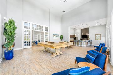 Orlando apartment for rent - A living room with a blue couch and a wooden table.