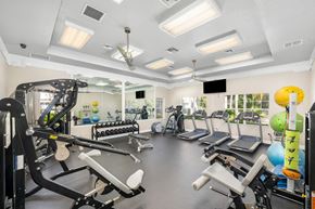 Orlando apartment for rent - A gym with a variety of equipment including treadmills, weights, and exercise machines.
