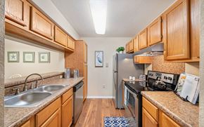 Gainesville apartment for rent - a kitchen with stainless steel appliances and wooden cabinets