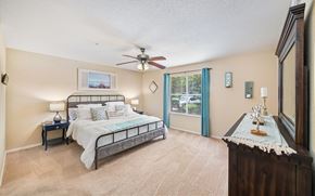 Gainesville apartment for rent - a bedroom with a bed and a ceiling fan
