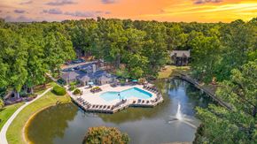 Charleston apartment for rent - an aerial view of a swimming pool and a lake with a fountain
