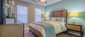Charleston apartment for rent - a bedroom with a bed and a dresser and two windows