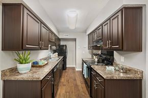 Summerville apartment for rent - a kitchen with dark wood cabinets and granite counter tops